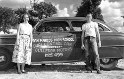 2 students posing in front of the San Marcos High School Dual Control Car.